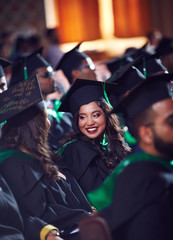 grroup of happy graduate students in gowns on graduation ceremony
