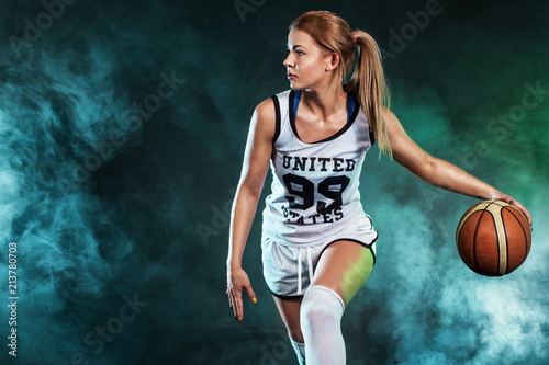 Portrait of a beautiful and sexy woman with a basketball in studio. Sport concept