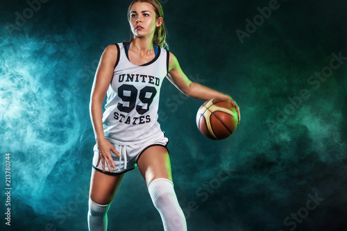 Portrait of a beautiful and sexy woman with a basketball in studio. Sport concept