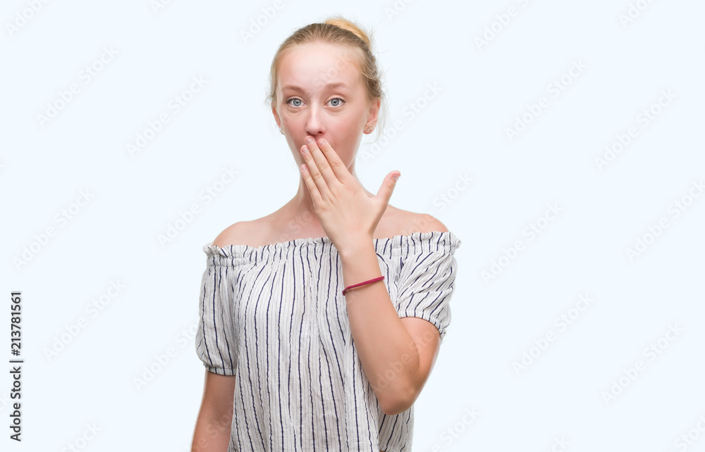 Blonde teenager woman wearing a bun cover mouth with hand shocked with shame for mistake, expression of fear, scared in silence, secret concept Blonde teenager woman wearing a bun cover mouth with hand shocked with shame for mistake, expression of fear, scared in silence, secret concept
