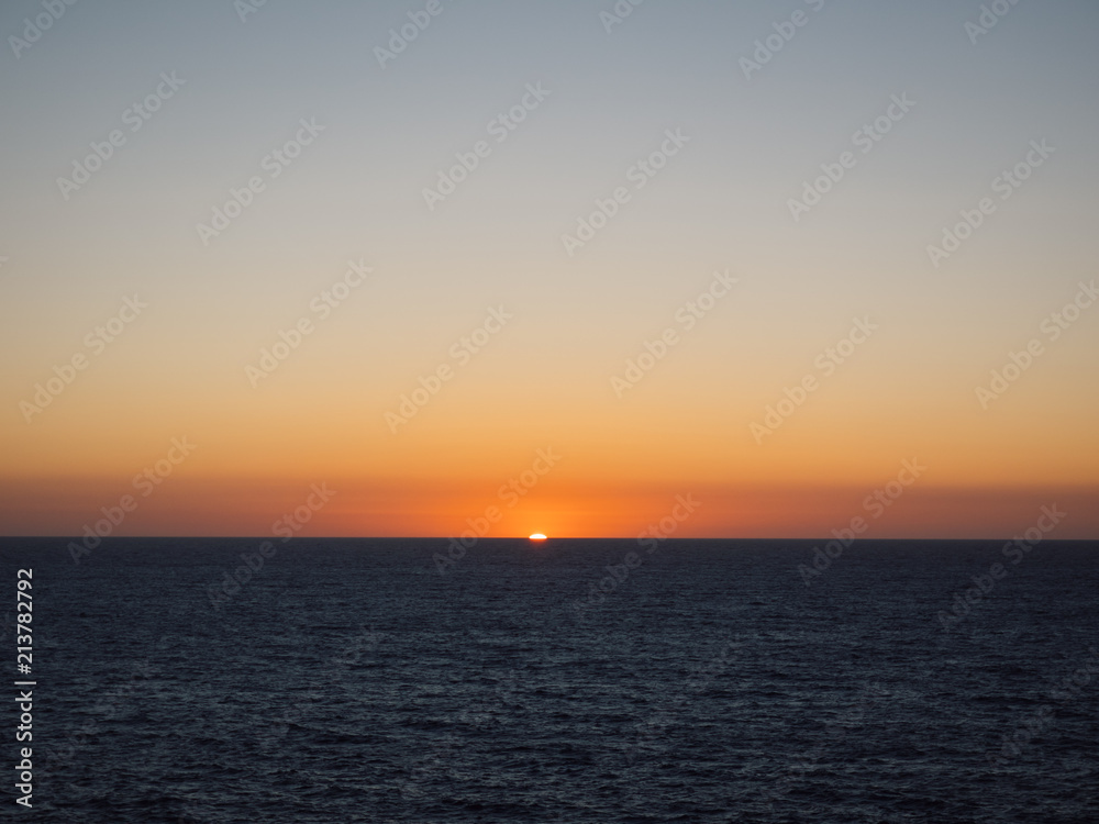 Orange sun setting over sea