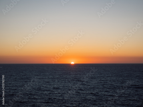 Orange sun setting over sea © Doug Armand