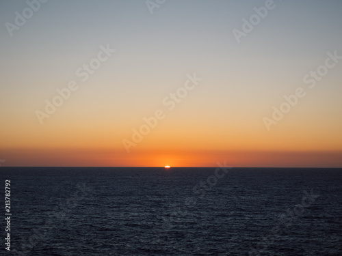 Orange sun setting over sea