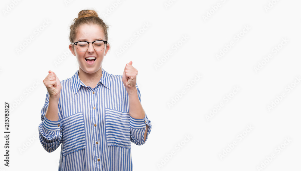 Young blonde business woman excited for success with arms raised celebrating victory smiling. Winner concept. Young blonde business woman excited for success with arms raised celebrating victory smiling. Winner concept.