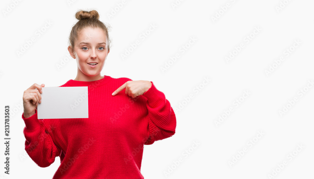 Young blonde woman holding advertising banner with surprise face pointing finger to himself Young blonde woman holding advertising banner with surprise face pointing finger to himself
