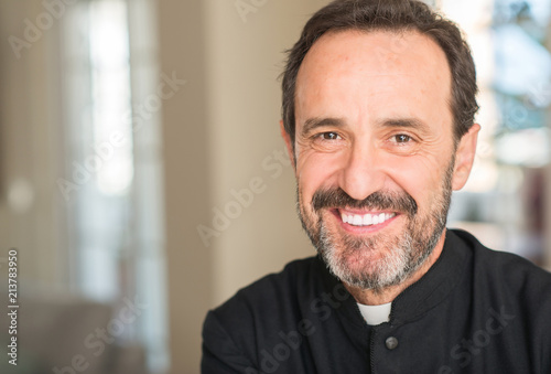 Murais de parede Christian priest man with a happy face standing and smiling with a confident smi