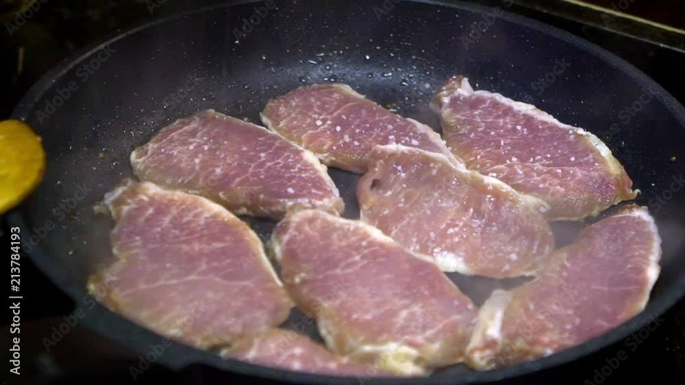 Slow motion of a cheff is cooking a pork tenderloin fried in pan at kitchen. Slowmo of pork fillet healthy living meal. Tasty a long thin cut of pork. Delicious nutritious organic dietary -Dan Slow motion of a cheff is cooking a pork tenderloin fried in pan at kitchen. Slowmo of pork fillet healthy living meal. Tasty a long thin cut of pork. Delicious nutritious organic dietary -Dan