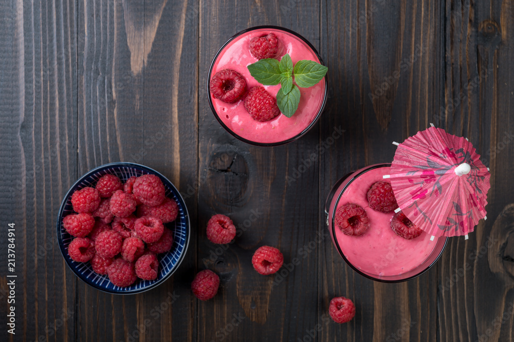 Raspberry smoothie or milk shake in a glass on wooden table, top view Raspberry smoothie or milk shake in a glass on wooden table, top view