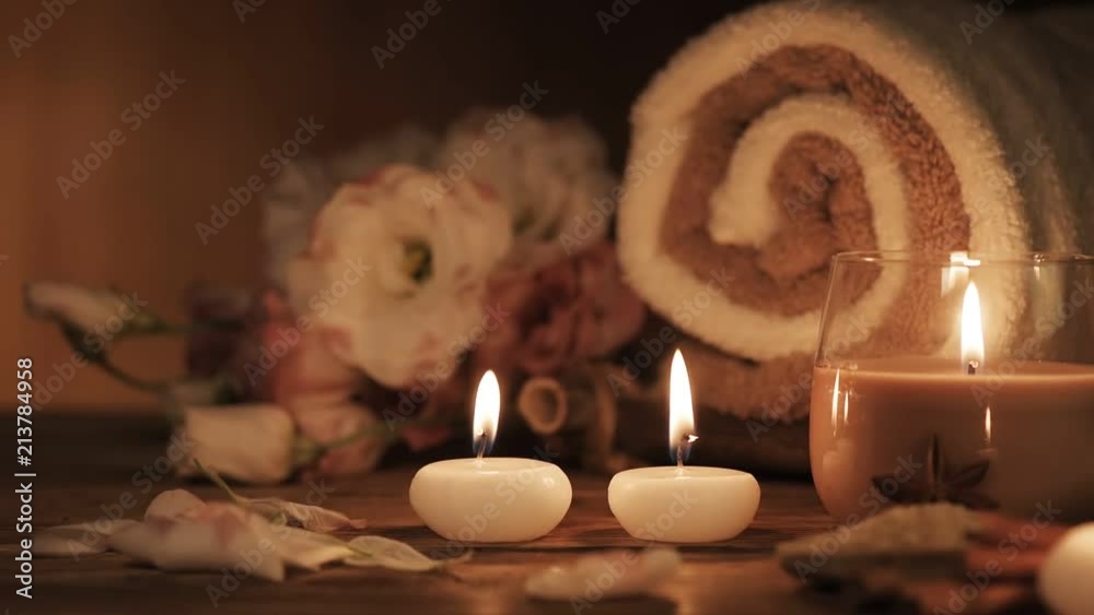 Cinemagraph - Spa still life with aromatic candles, flowers and towel. Living foto.