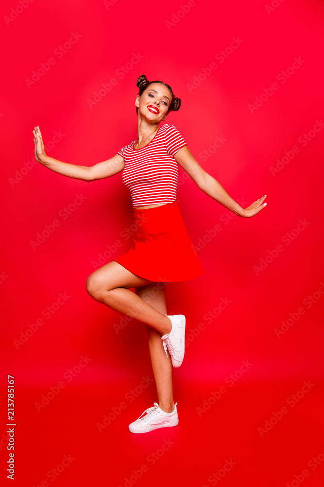Full-legh and full-body vertical photo of charming, lovely and cute young woman isolated on red vivid background