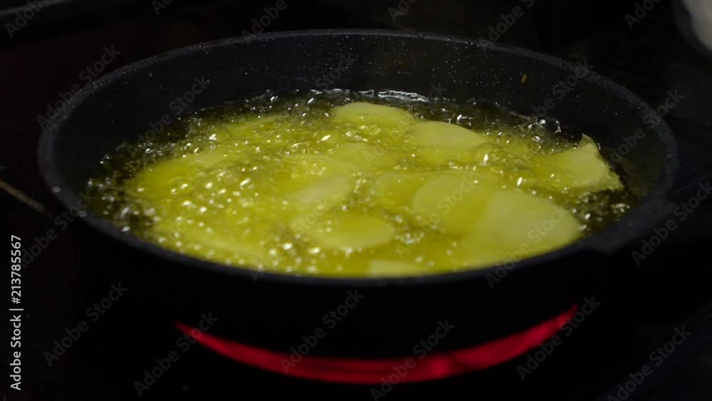 4K, Frying foods in a pan with high temperature until several bubbles appear in oil. French fries cooking. Potato lowered into boiling oil. The concept of fast food, delicious food, restaurant-Dan
