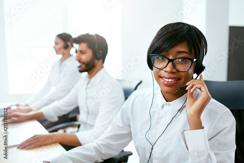 Call Center Operator With Colleagues At Workplace photo