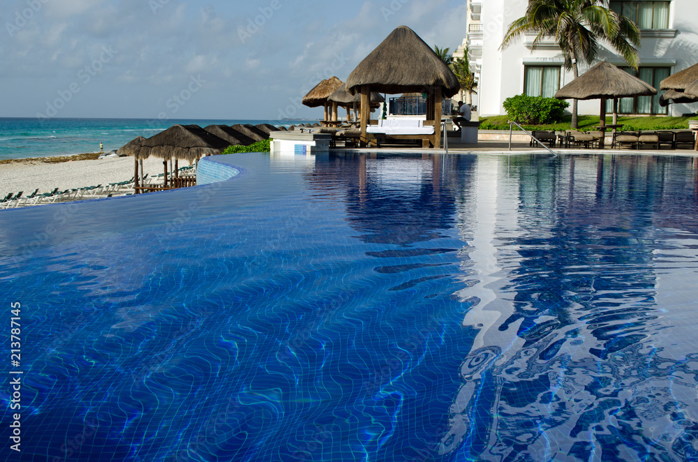 Fototapeta premium Infinity edge swiming pool. Summer, sand