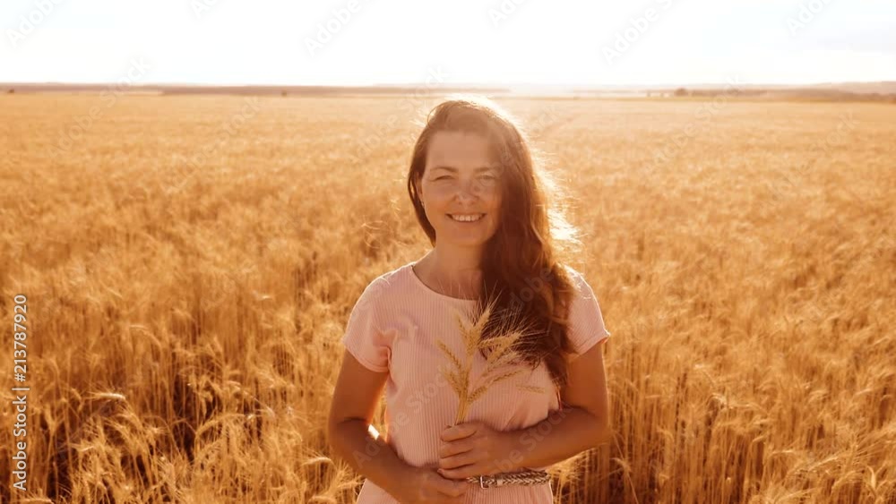 portrait beautiful woman smiling. girl fashion model in slow motion video white dress on field wheat. sexy woman on nature in the field grass flowers lifestyle summer. agriculture. girl length portrait beautiful woman smiling. girl fashion model in slow motion video white dress on field wheat. sexy woman on nature in the field grass flowers lifestyle summer. agriculture. girl length