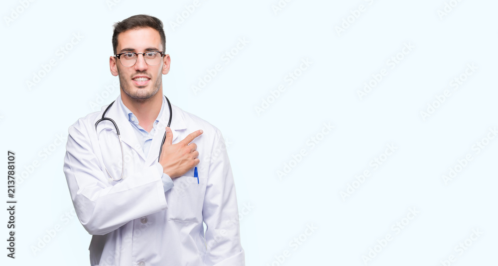 Handsome young doctor man cheerful with a smile of face pointing with hand and finger up to the side with happy and natural expression on face looking at the camera. Handsome young doctor man cheerful with a smile of face pointing with hand and finger up to the side with happy and natural expression on face looking at the camera.