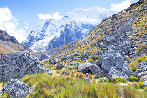 Scenic view of Salkantay snowy Andean mountain, rocky path from a trek to Machu Picchu .