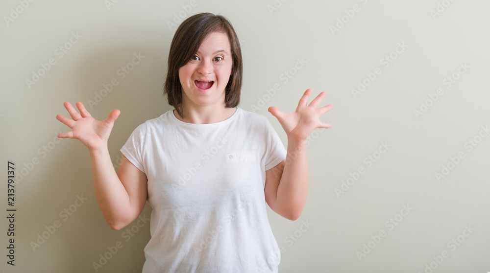 Down syndrome woman standing over wall celebrating mad and crazy for success with arms raised and closed eyes screaming excited. Winner concept Down syndrome woman standing over wall celebrating mad and crazy for success with arms raised and closed eyes screaming excited. Winner concept