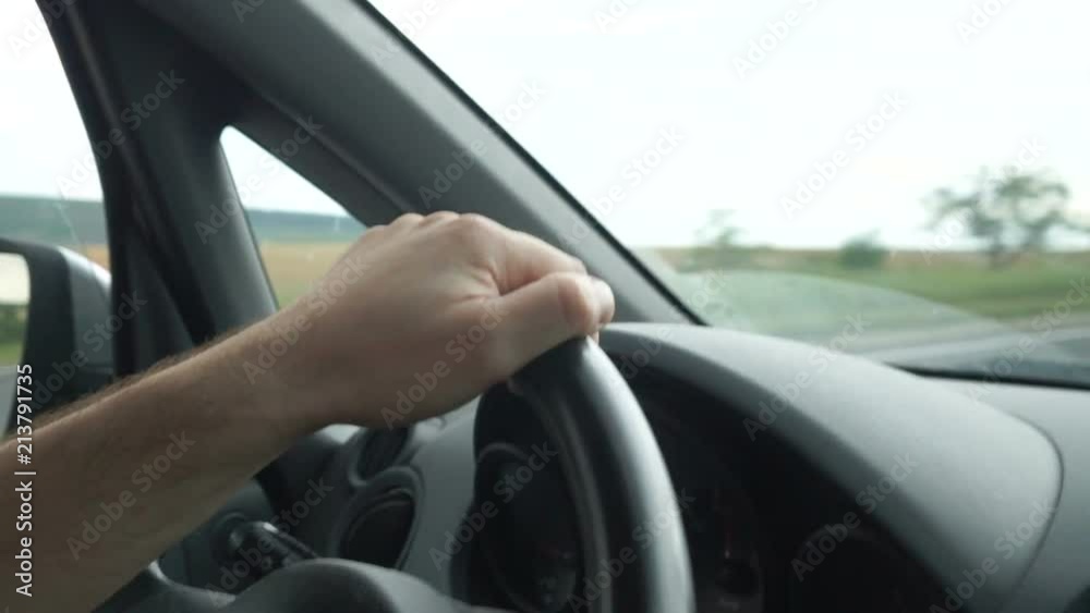 Man's hands holding steering wheel of car Man's hands holding steering wheel of car