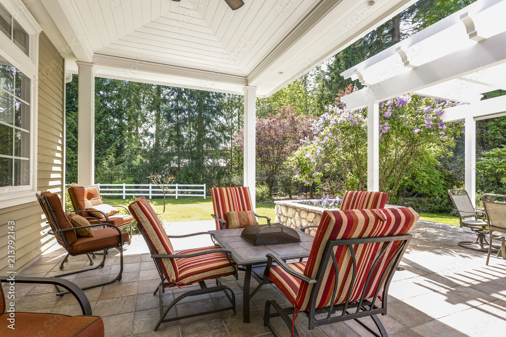 Spacious covered deck patio with table and red chairs. Spacious covered deck patio with table and red chairs.