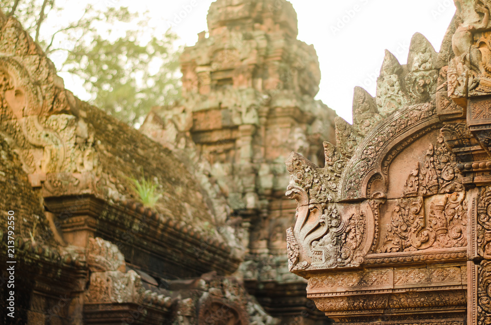Naklejka premium Carved stone decors on Bantai Srei buddhist temple's roofs in Angkor Wat park, Cambodia