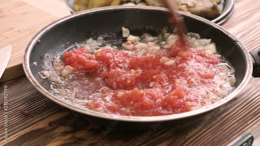 the chef mixes onion with tomatoes in the pan the chef mixes onion with tomatoes in the pan