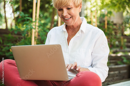 Happy mature woman using laptop computer