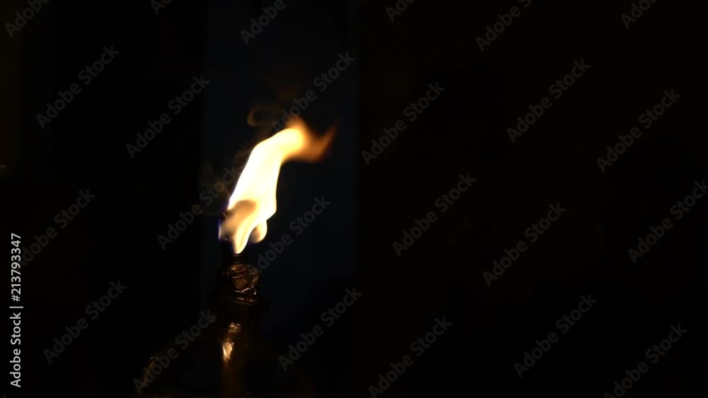 Slow Motion of a traditional kerosene lamp isolated in a dark area. Soil or clay lamp radiating light in dark. Concept of removing darkness with a flame. Lamp has oil and cotton wick-Dan