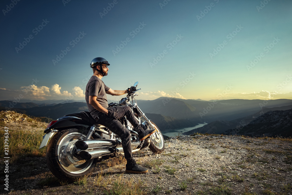 Fototapeta premium Rowerzysta oparty na motocyklu