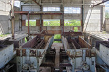 Large abandoned industrial building interior. Ruined sugar refinery with rusty remnant of equipment 