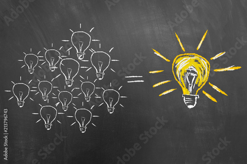 Brainstorming concept with light bulb on chalkboard or blackboard.