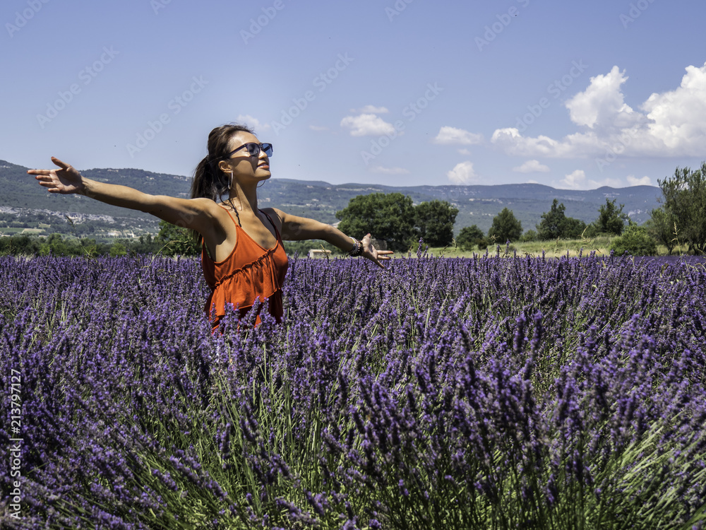 Asian woman solo traveller enjoying the full blooming of lavender field in Provence, France
