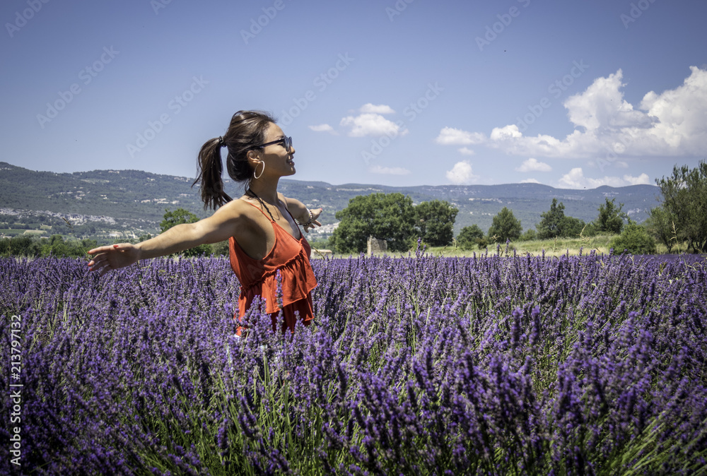 Asian woman solo traveller enjoying the full blooming of lavender field in Provence, France