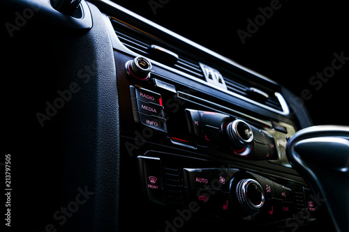 Modern Luxury sport car inside. Interior of prestige car. Black Leather. Car detailing. Dashboard. Media, climate and navigation control buttons. Sound system. Modern car interior details