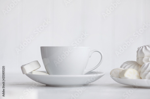 Cup of coffee on white background. Marshmallows, sweets and coffee beans.