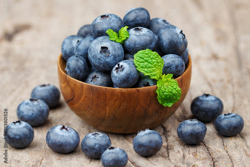 Blueberries in a wood bowl on a wooden table, Healthy eating and nutrition concept Blueberries in a wood bowl on a wooden table, Healthy eating and nutrition concept