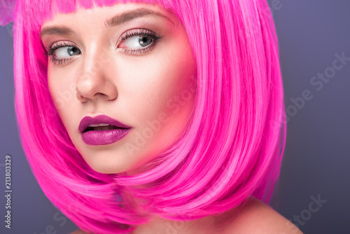 beautiful young woman with pink bob cut isolated on violet