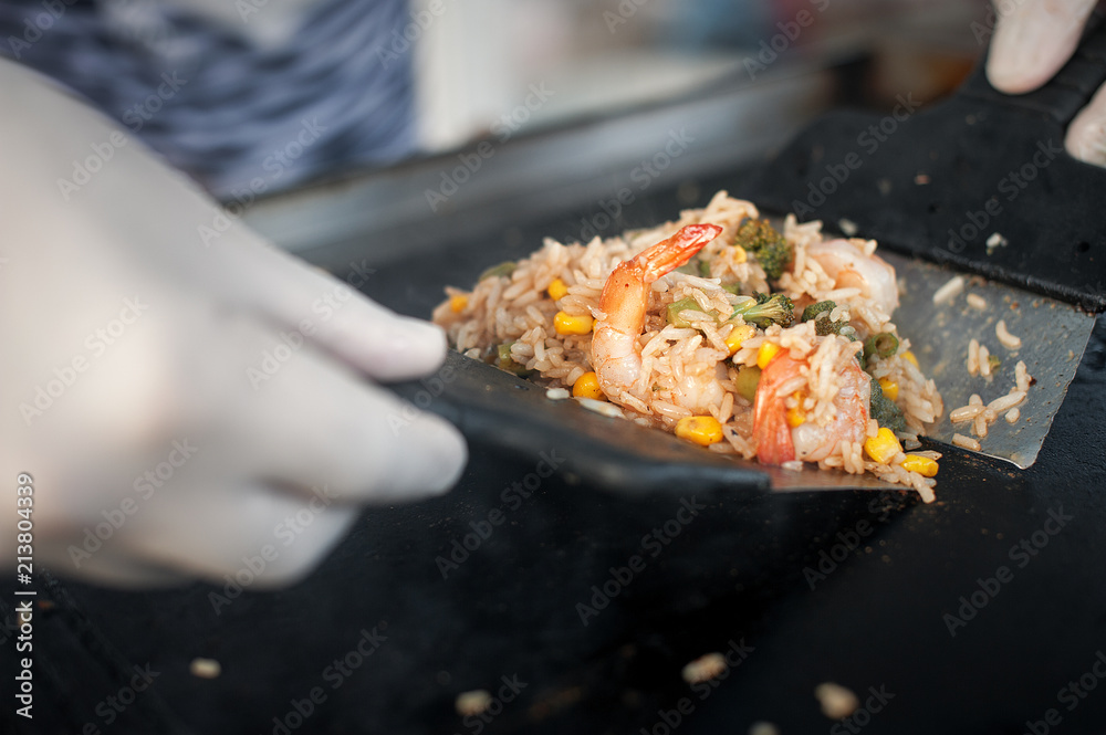 The process of cooking rice with vegetables. Asian cuisine. Street food.