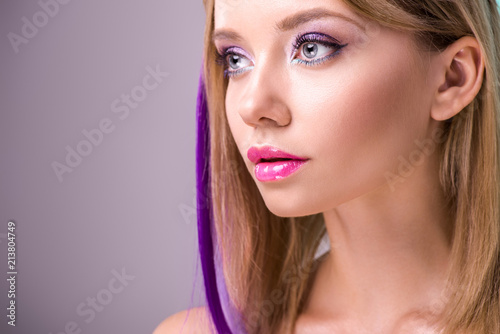 close-up portrait of beautiful young woman with colorful strands in hair looking away