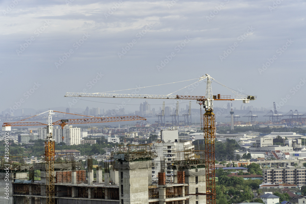 Industrial construction cranes and building on city background Industrial construction cranes and building on city background