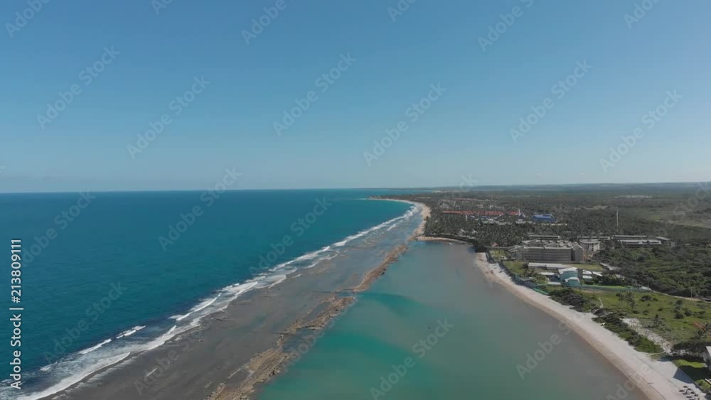 blue sea and waves hitting reef near palm trees in pernambuco, brazil blue sea and waves hitting reef near palm trees in pernambuco, brazil