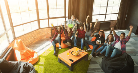 Happy football fans watching soccer on tv