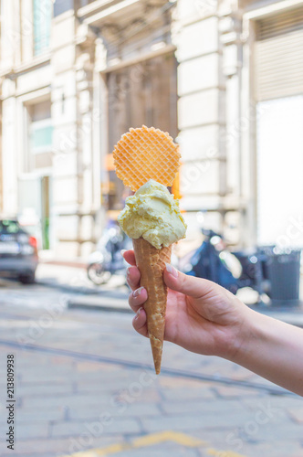 Italian ice cream in waffle cone in woman hand.