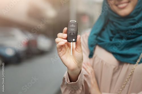 Muslim woman in hijab with car key