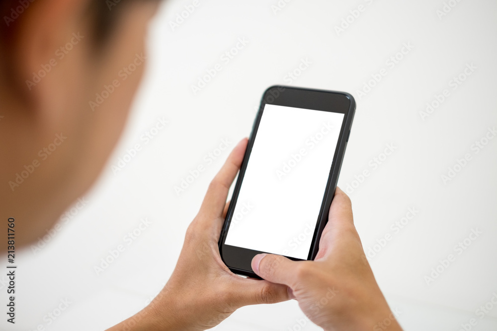 Man holding and using smartphone in office.