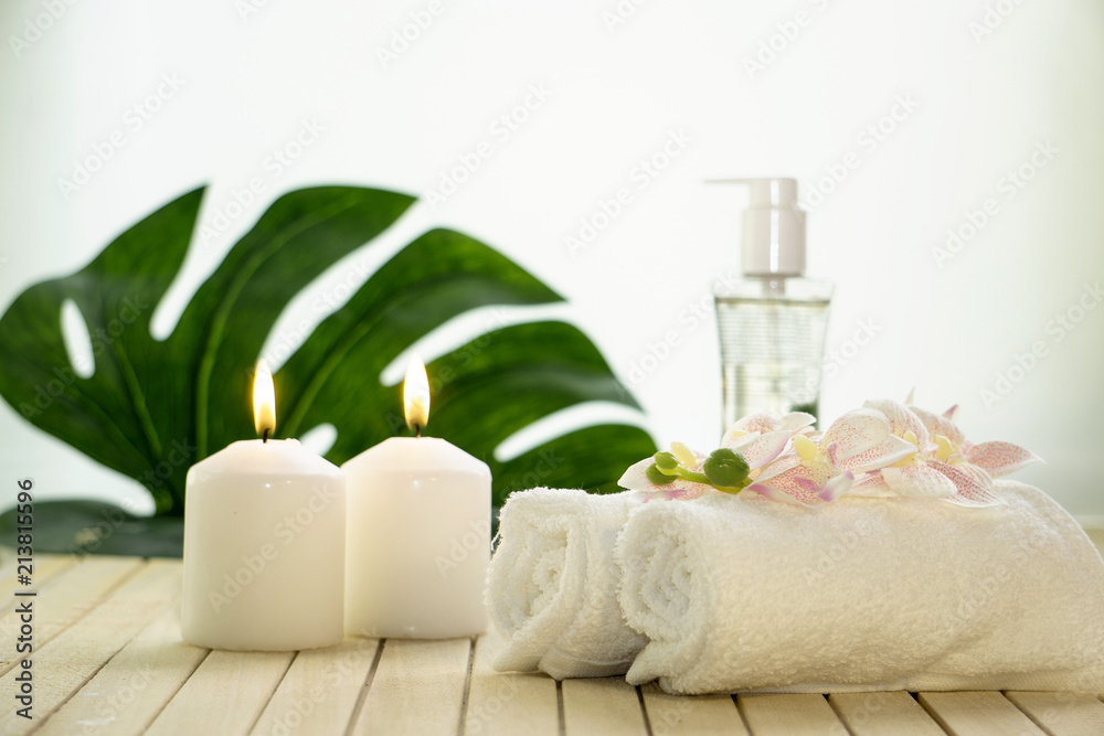 Spa setting still life with orchid flower , candle, soap and towels on white background Spa setting still life with orchid flower , candle, soap and towels on white background