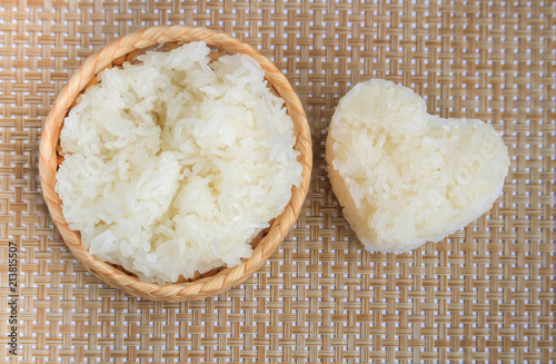 sticky rice in heart shape in the bamboo wicker on wood floor.