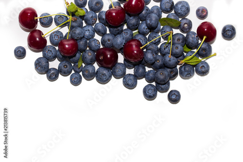 Fresh cherries and blueberries on white isolated background. Top view