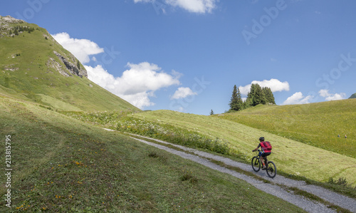 active senior woman, riding her e-mountainbike in the Arlberg area near Lech,Tirol,Austria