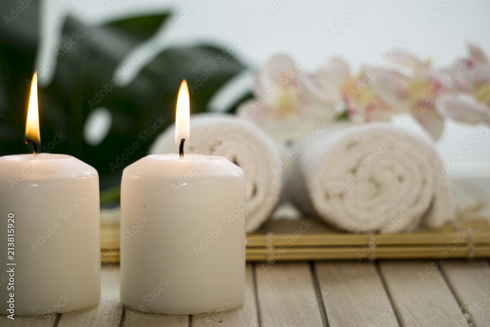 Elements for spa candles, soap, palm leaves and yellow orchids on a white wooden background. View from above Elements for spa candles, soap, palm leaves and yellow orchids on a white wooden background. View from above