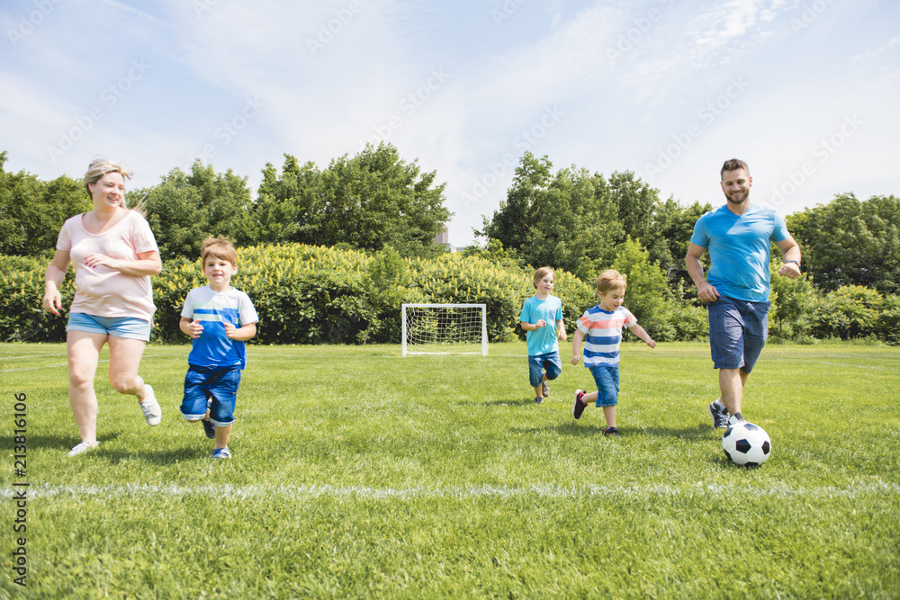 Man with child playing football outside on field Man with child playing football outside on field
